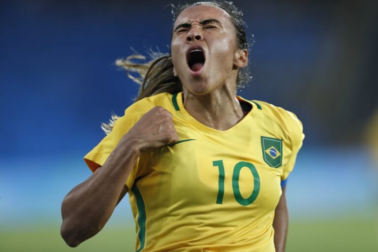 Jogadora brasileira de futebol feminino Marta, vestindo a camisa verde e amarela número 10, comemorando.
