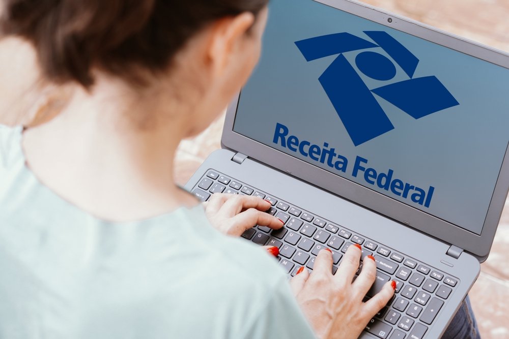Pessoa com um computador, acessando o site da Receita Federal.
